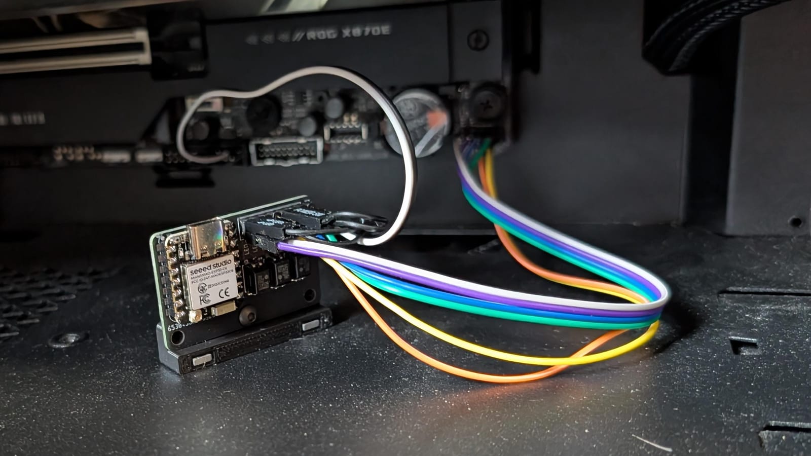 The PC Power Controller: a small ESP32 board wired with colored jumper cables to a PC motherboard's front-panel header